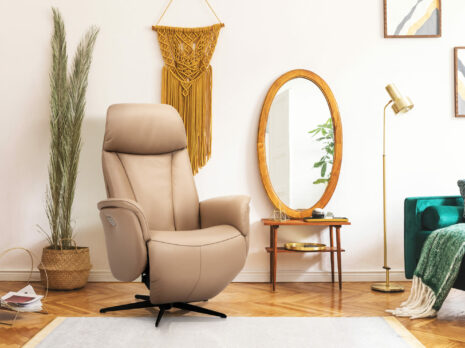 Fauteuil de relaxation beige THEO en cuir dans un salon style bohème chic, avec un miroir ovale, un cactus vert dans un panier en osier l Géant du Meuble