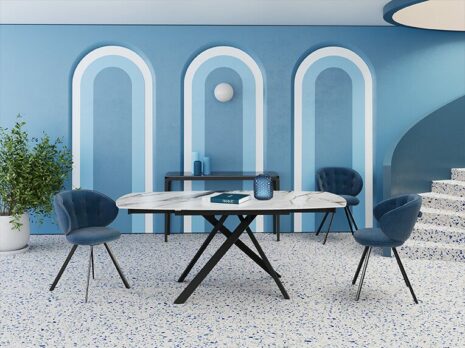 Table à manger STROMBOLI Table de repas STROMBOLI de forme rectangulaire avec un effet marbre et des quatre pieds noirs rigides dans un salon bleu avec un verre et un livre bleu sur la table et deux chaises bleues l Géant du Meuble